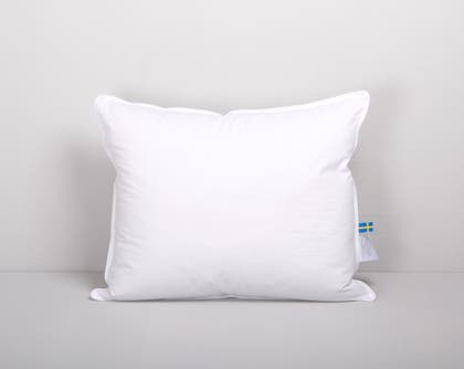 Vit rektangulär kudde mot en ljusgrå bakgrund.